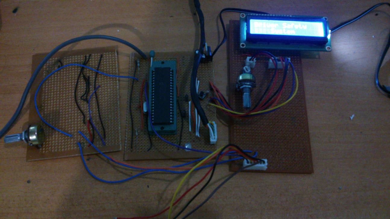 Prototype circuit boards with the PIC18F452 microcontroller and an LCD showing 'Driver Safety System'